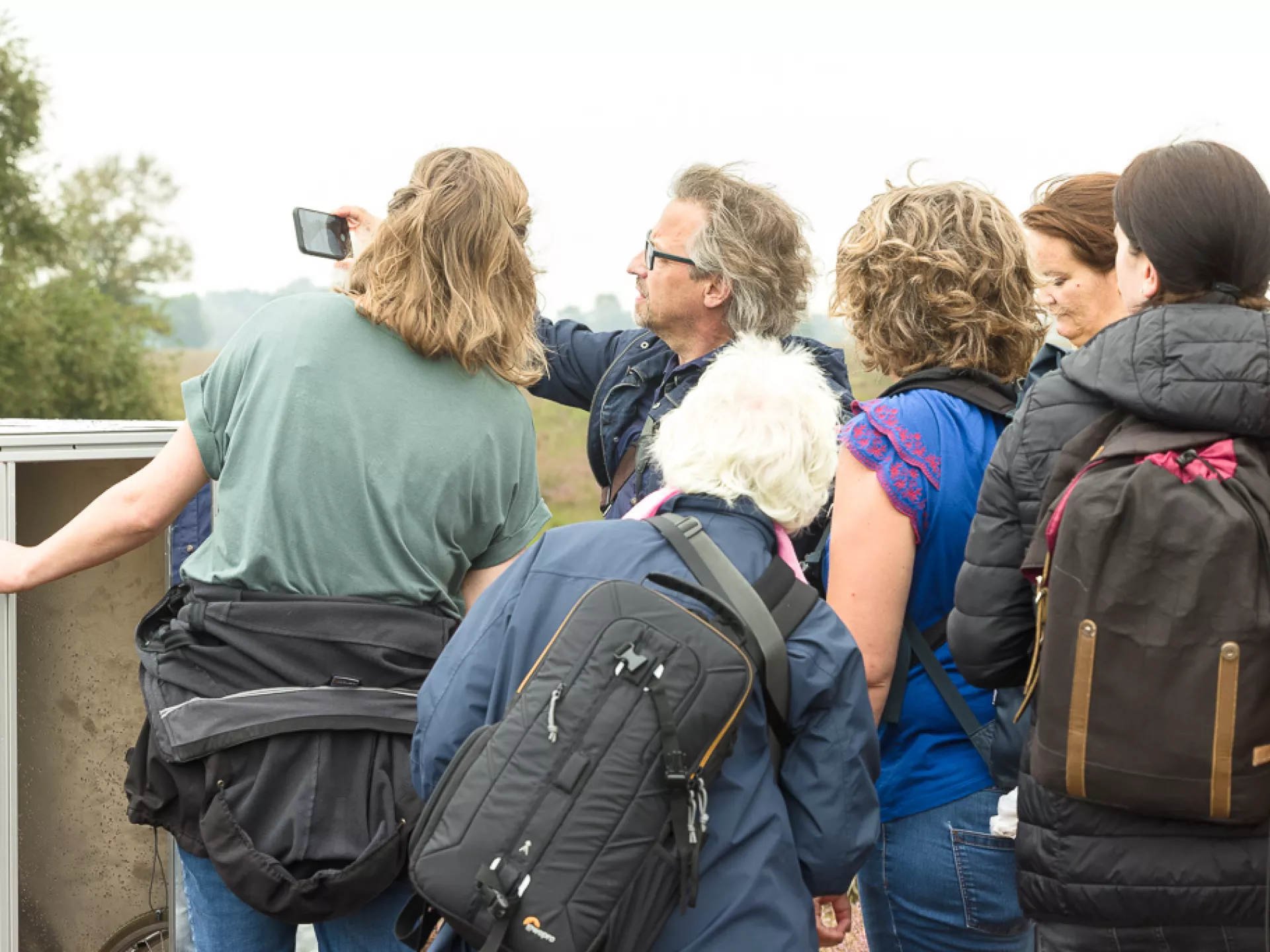 Groep mensen die naar iets in de natuur kijken.