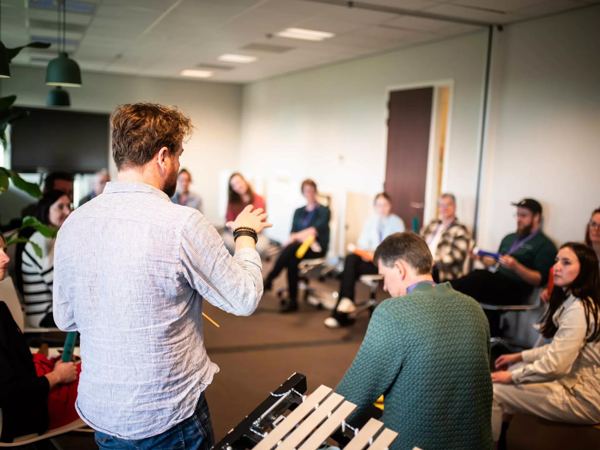 Een groep mensen in een kring tijdens een vergadering of workshop in een kantooromgeving.