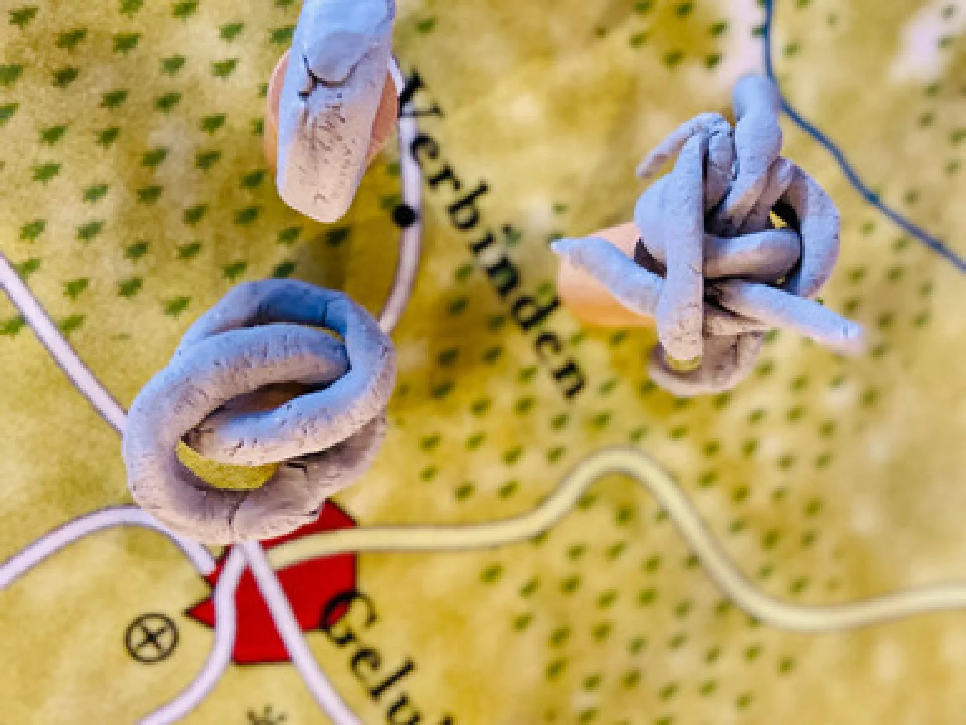 Kaart met draden en knopen geplaatst nabij een rode markering.