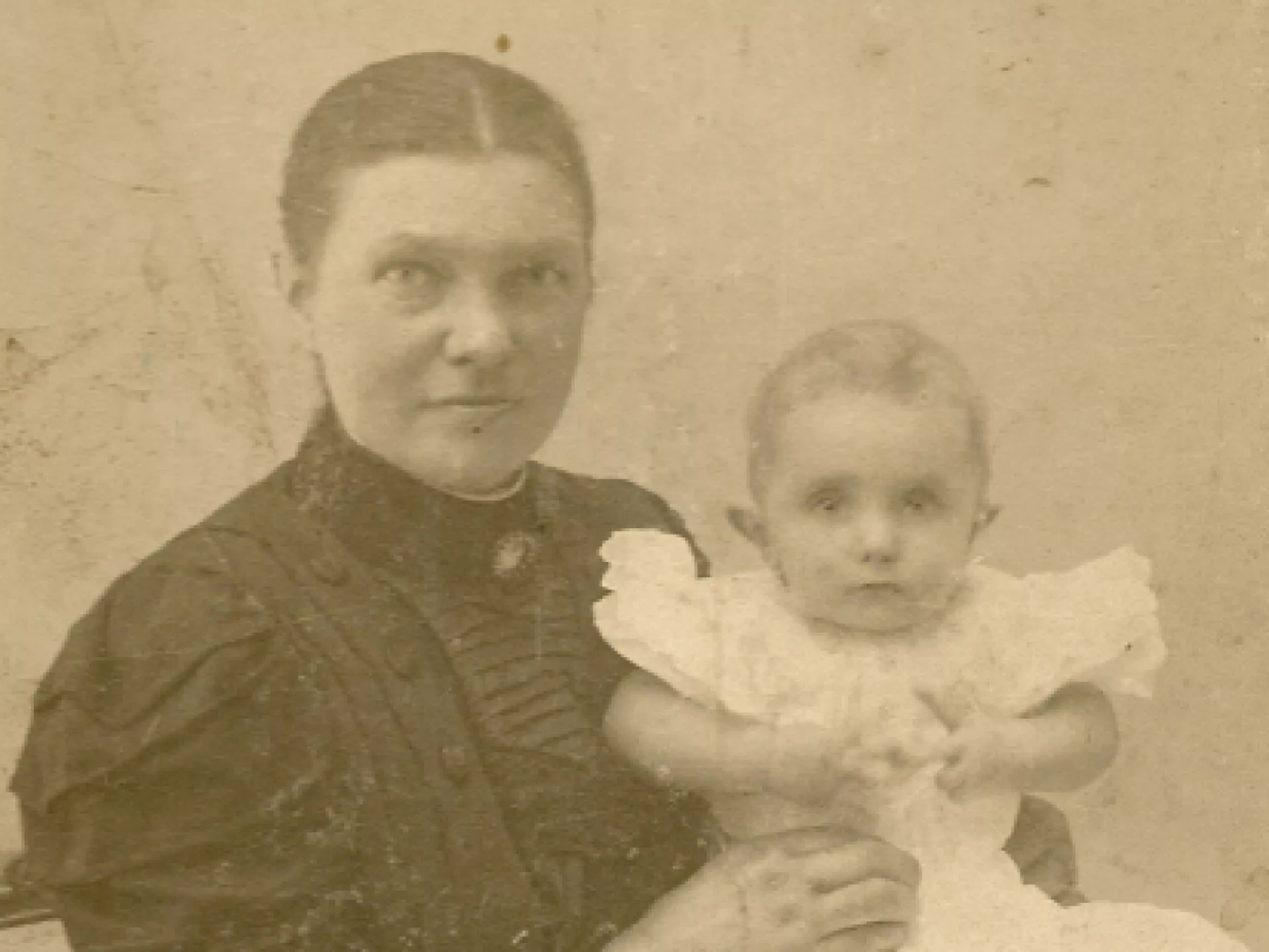 Oude vergeelde foto van vrouw en baby