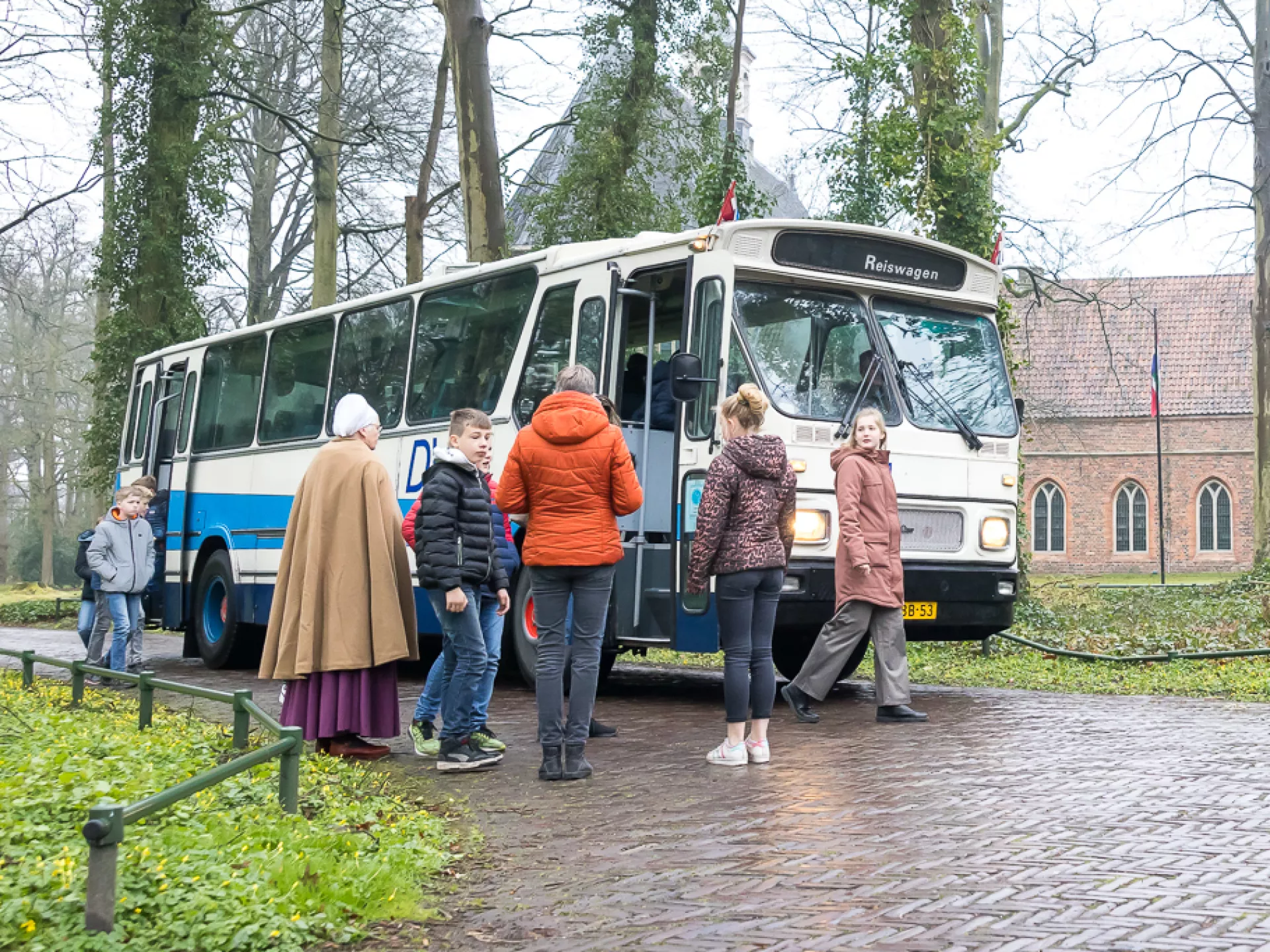 Enkele mensen stappen in een bus op een mistige dag.