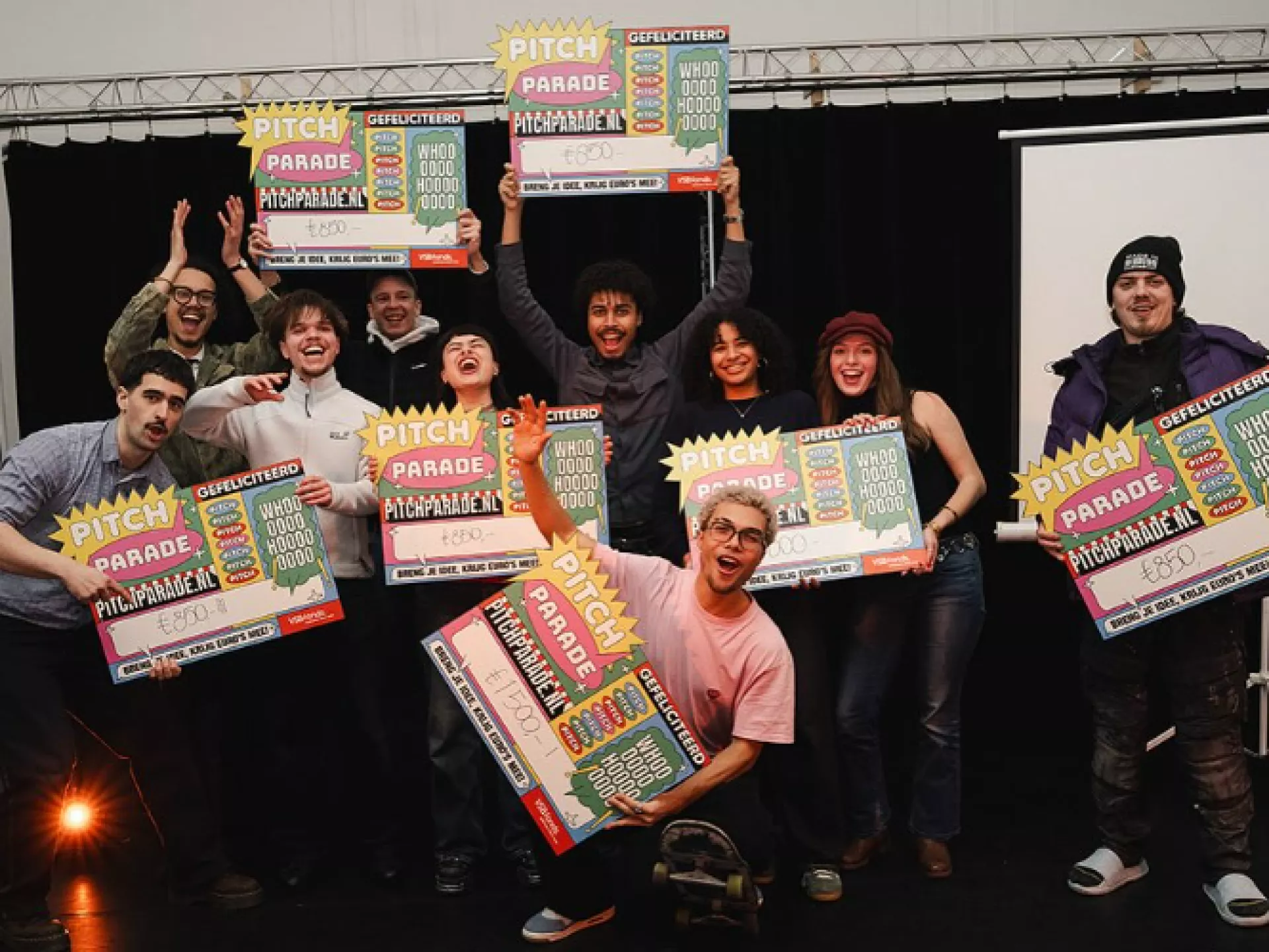 Groep mensen viert een overwinning met kleurrijke posters.