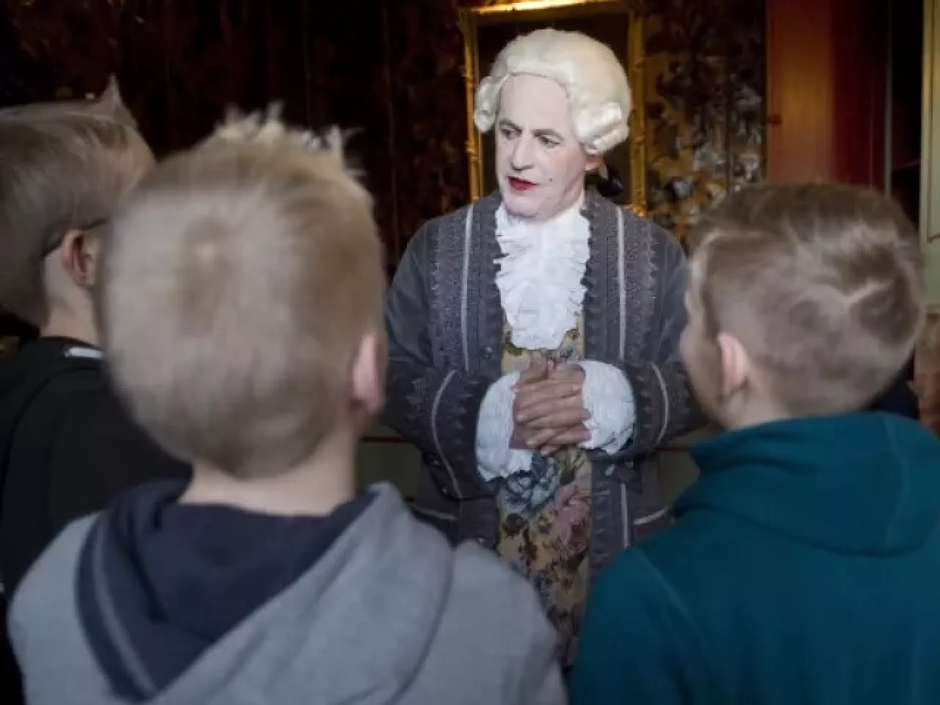 Een historische gids vertelt een groep kinderen een verhaal.