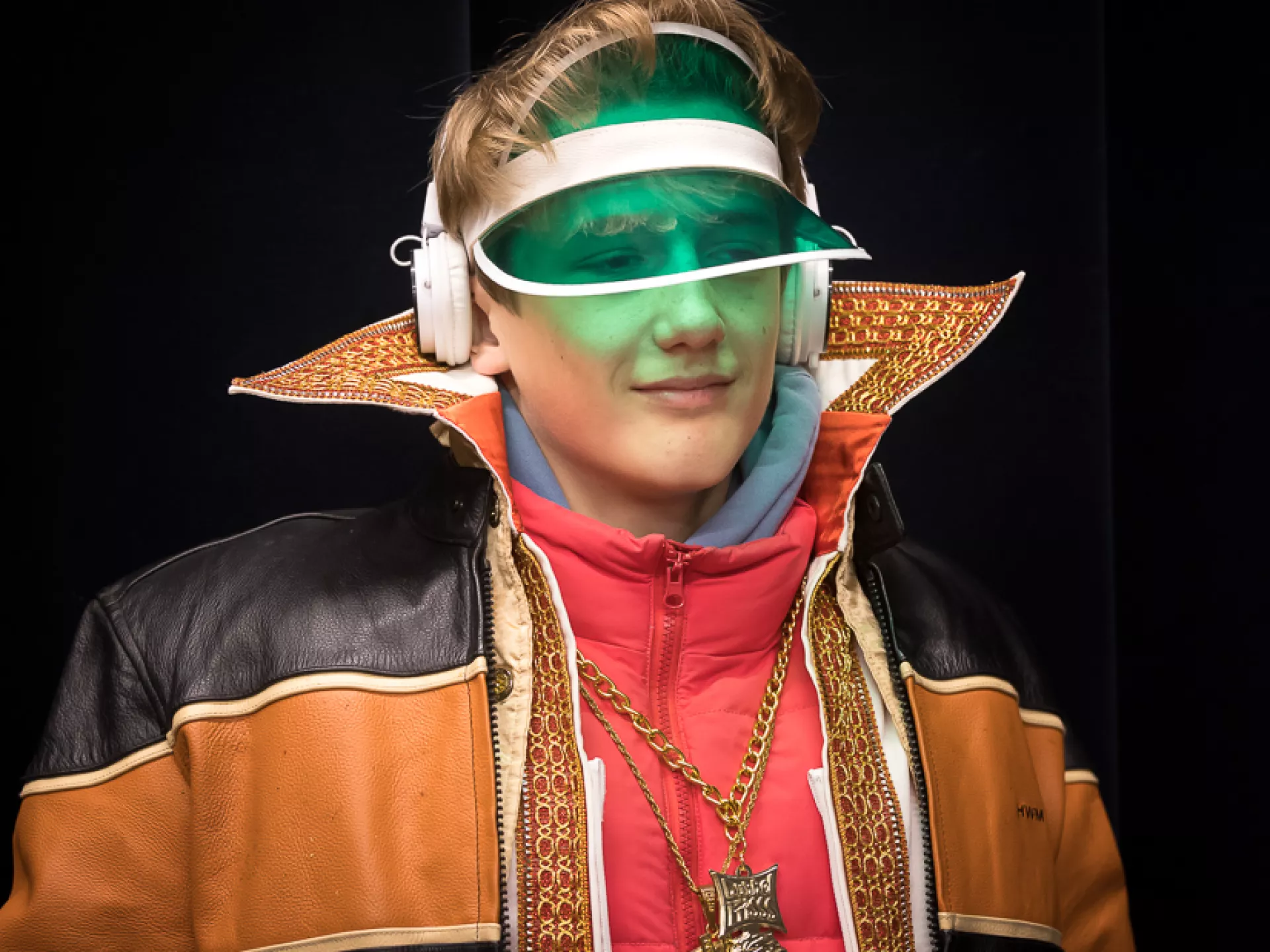 Jongen met groene zonneklep, hoge kraag en gouden ketting