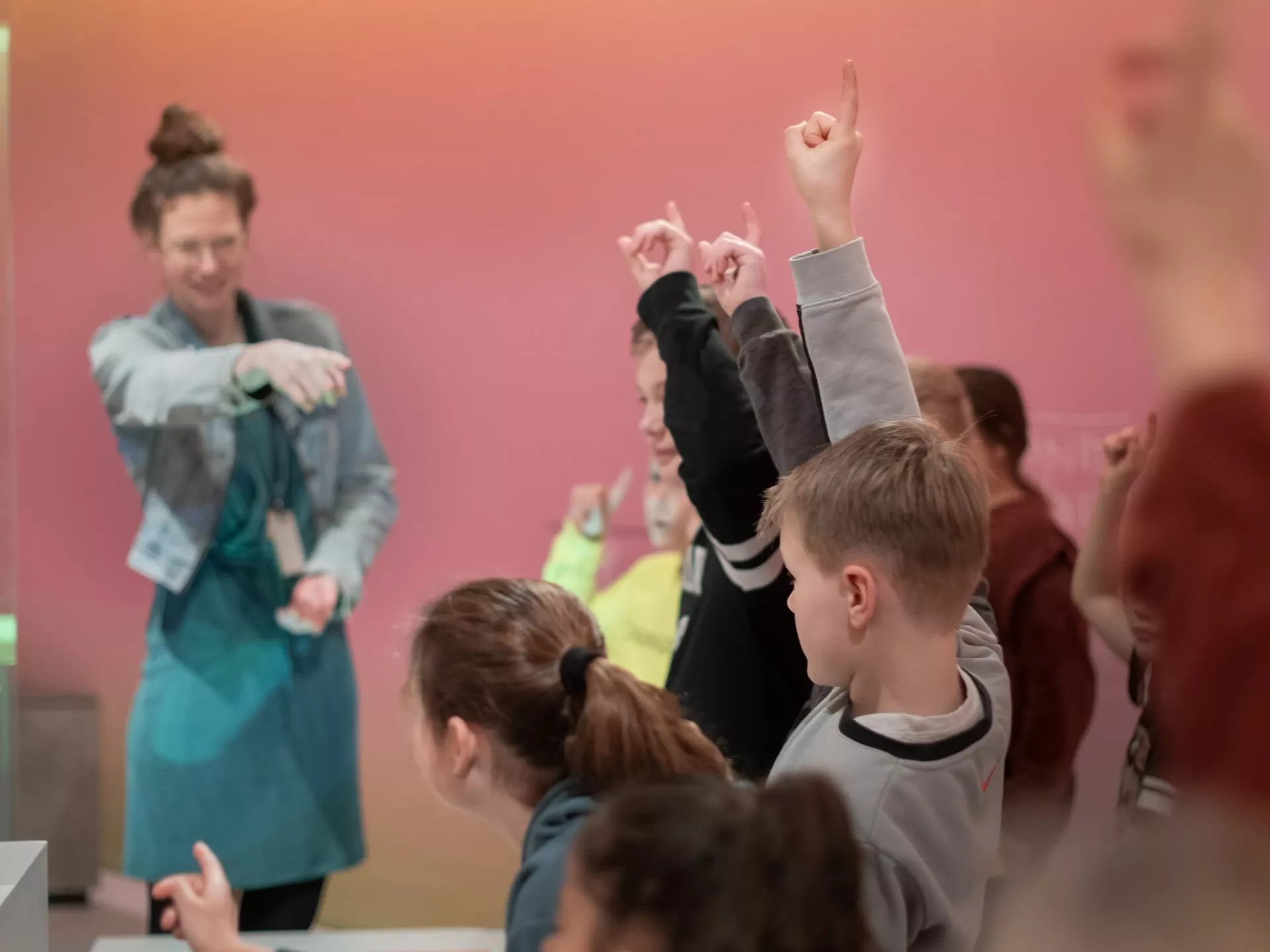 Kinderen steken hun handen op in een klaslokaal.