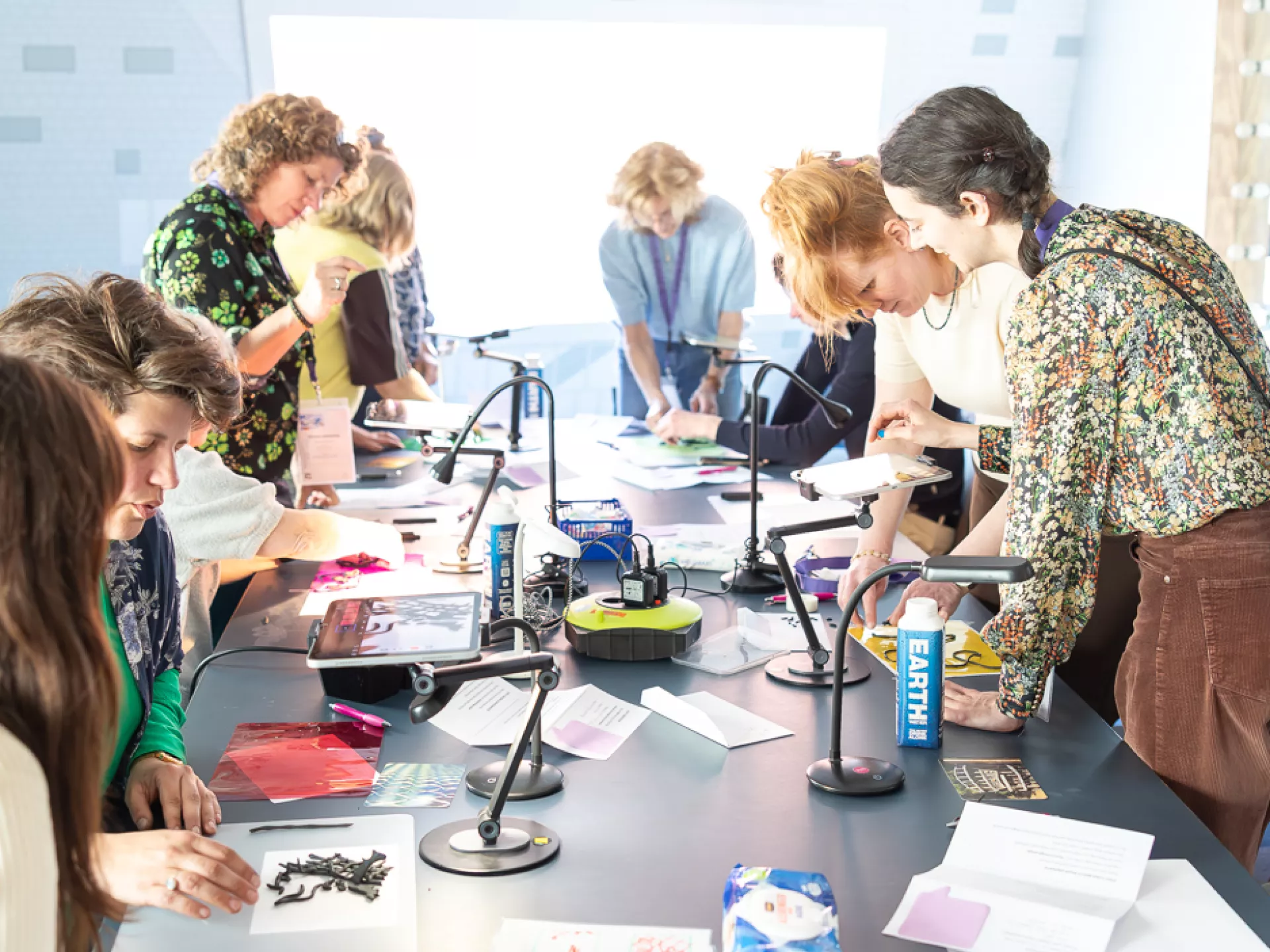 Groep mensen werkt samen aan een creatieve activiteit rond een tafel.