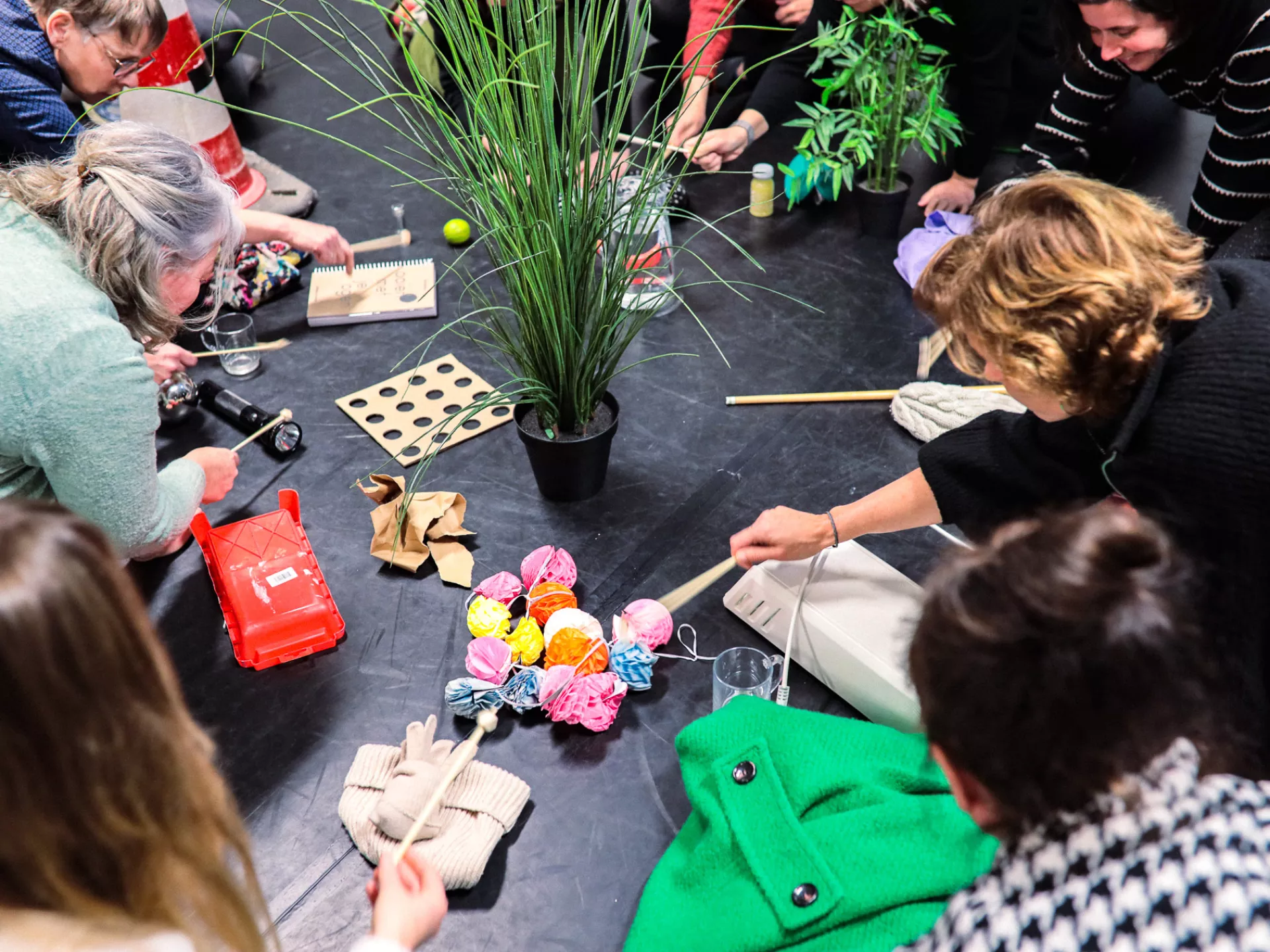 Mensen creëren muziek met alledaagse voorwerpen in een creatieve workshop.