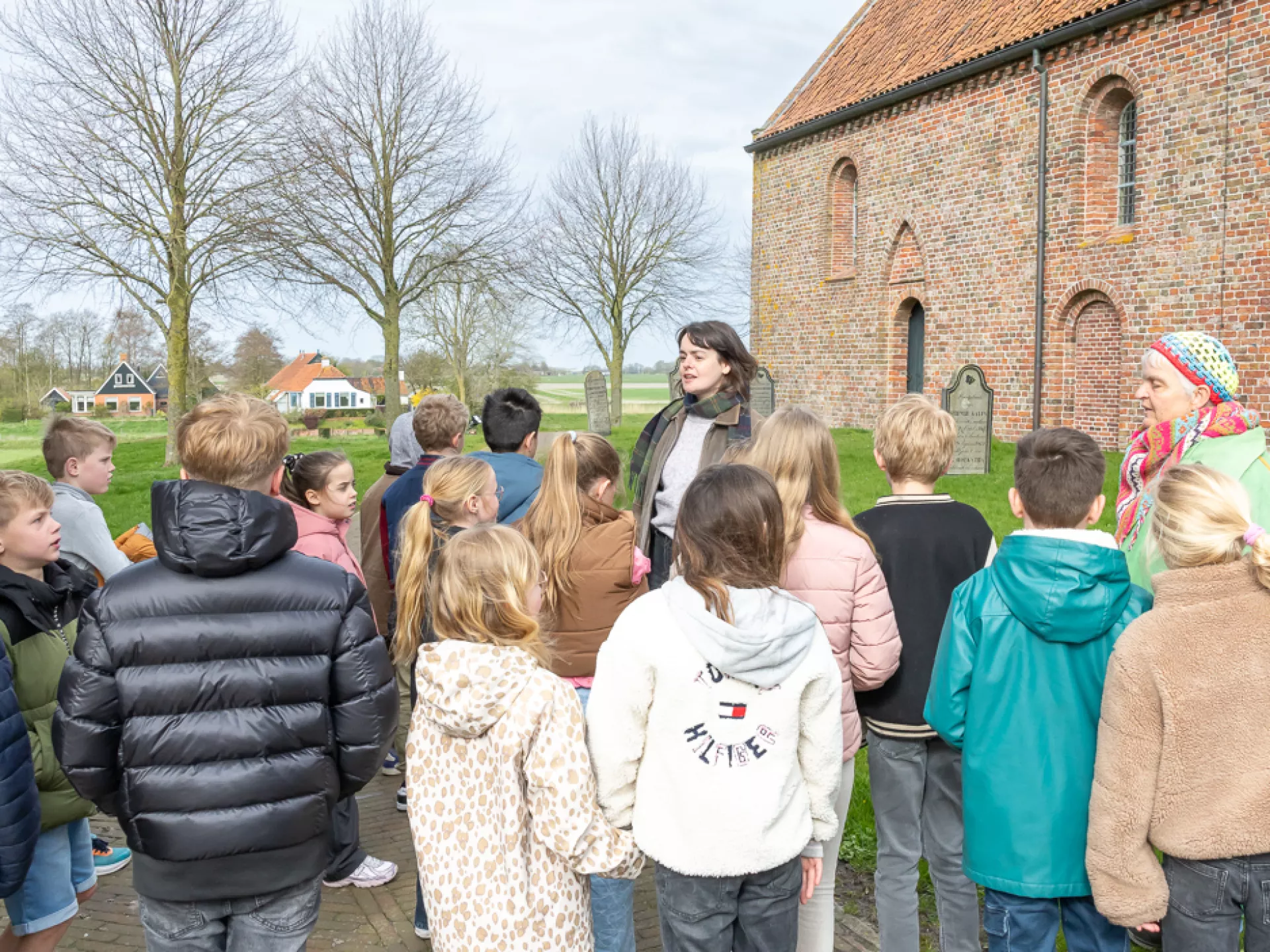Groep kinderen tijdens een rondleiding bij een kerk museum Wierdenland.