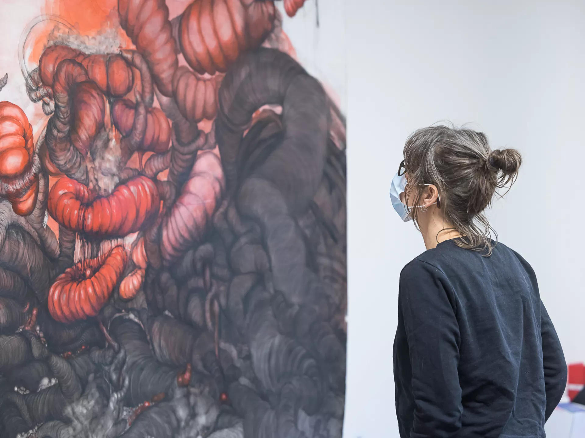 Ondernemers - kunstborrel - Iemand staat voor een schilderij met rode kleuren