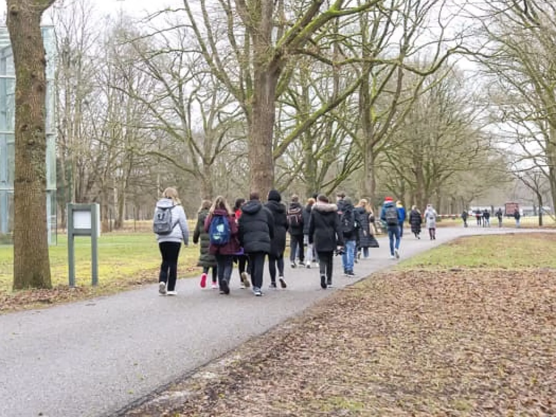 Jongeren lopen langs de kampwoning op het terrein van Herinneringscentrum Kamp Westerbork