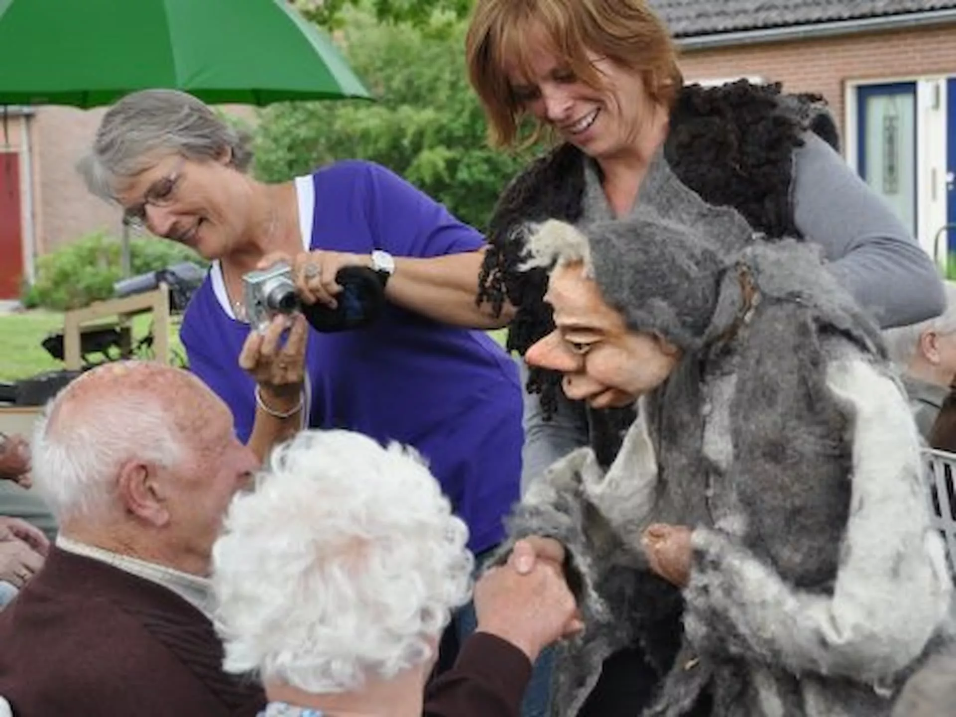 Een poppenspeler amuseert een groep mensen buiten.