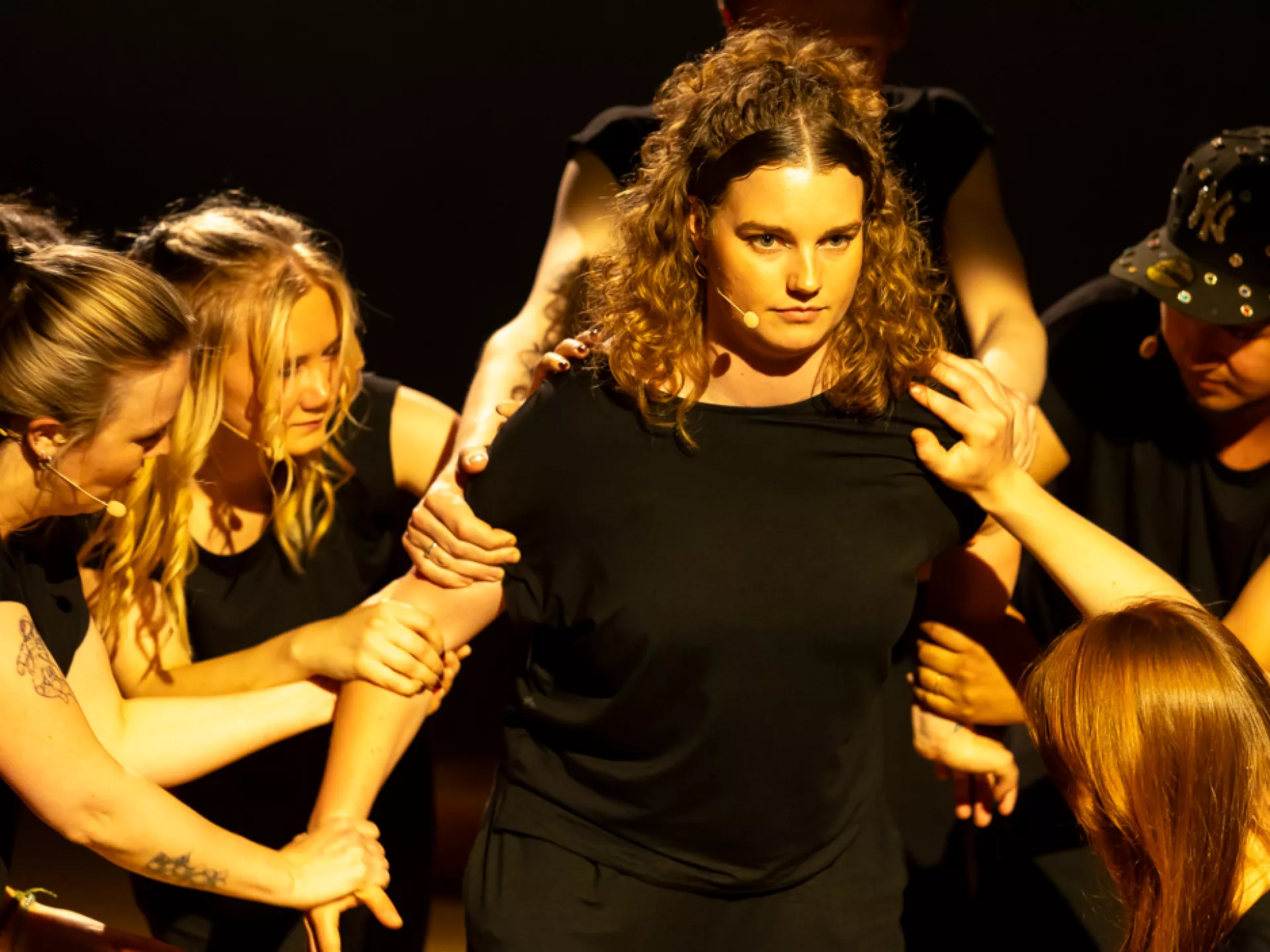 Een groep mensen voert een dramatische scène op in het theater.