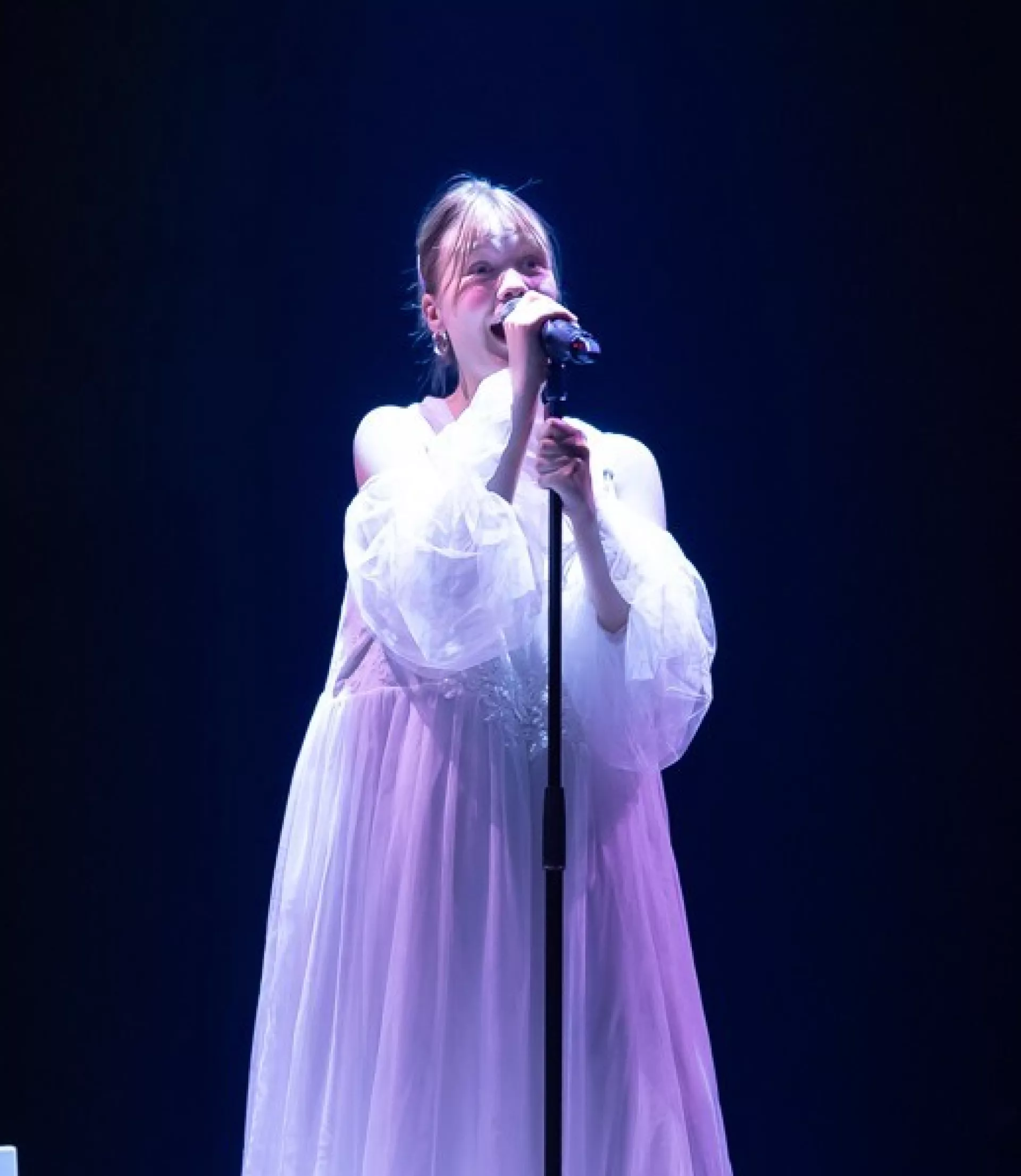 Festivals - februari - vrouw in lange witte jurk zingend op podium