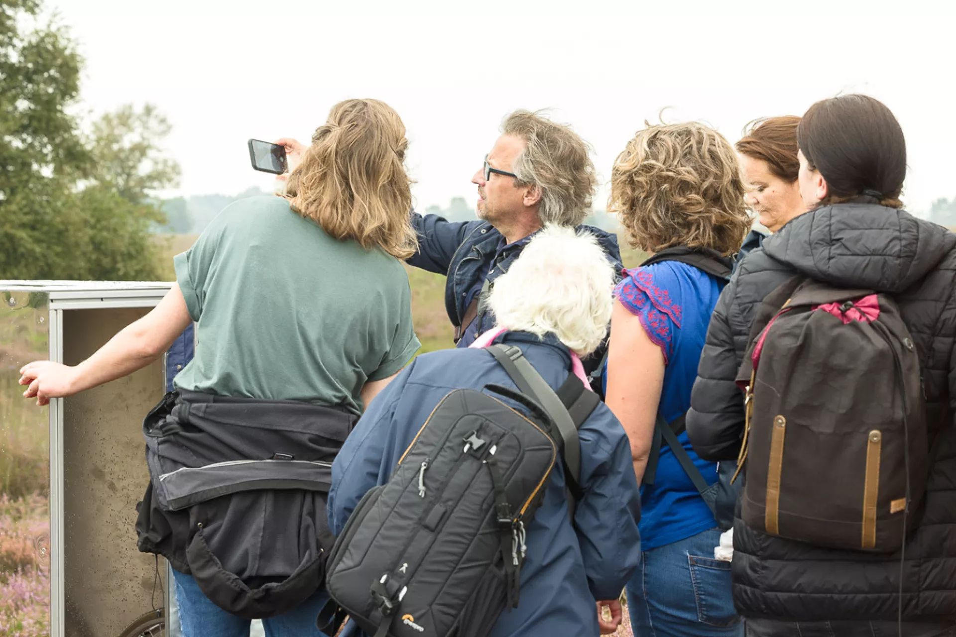 Groep mensen die naar iets in de natuur kijken.