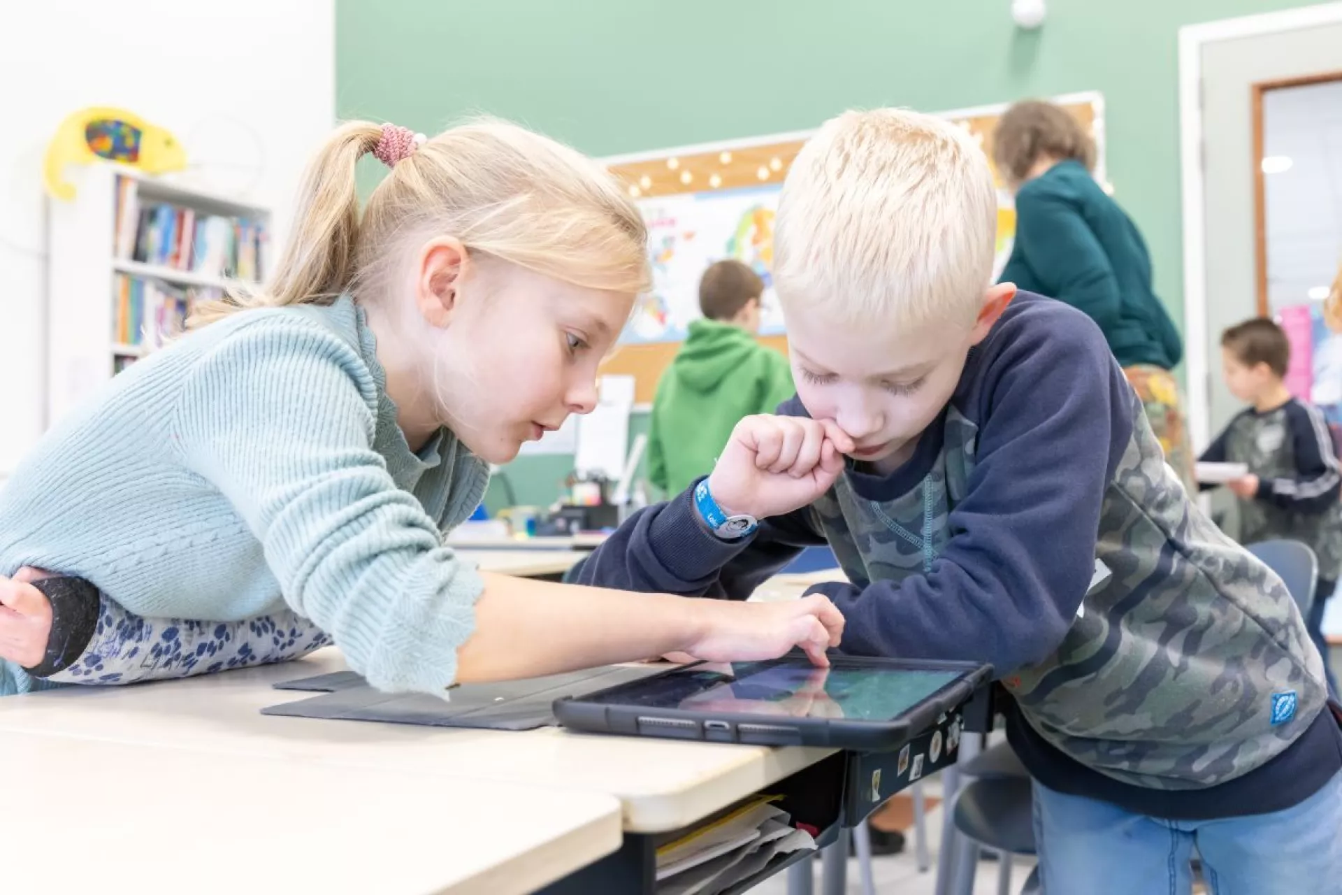 Primair Onderwijs - Kinderboekenweek -  2 kinderen in de klas gebogen over boek