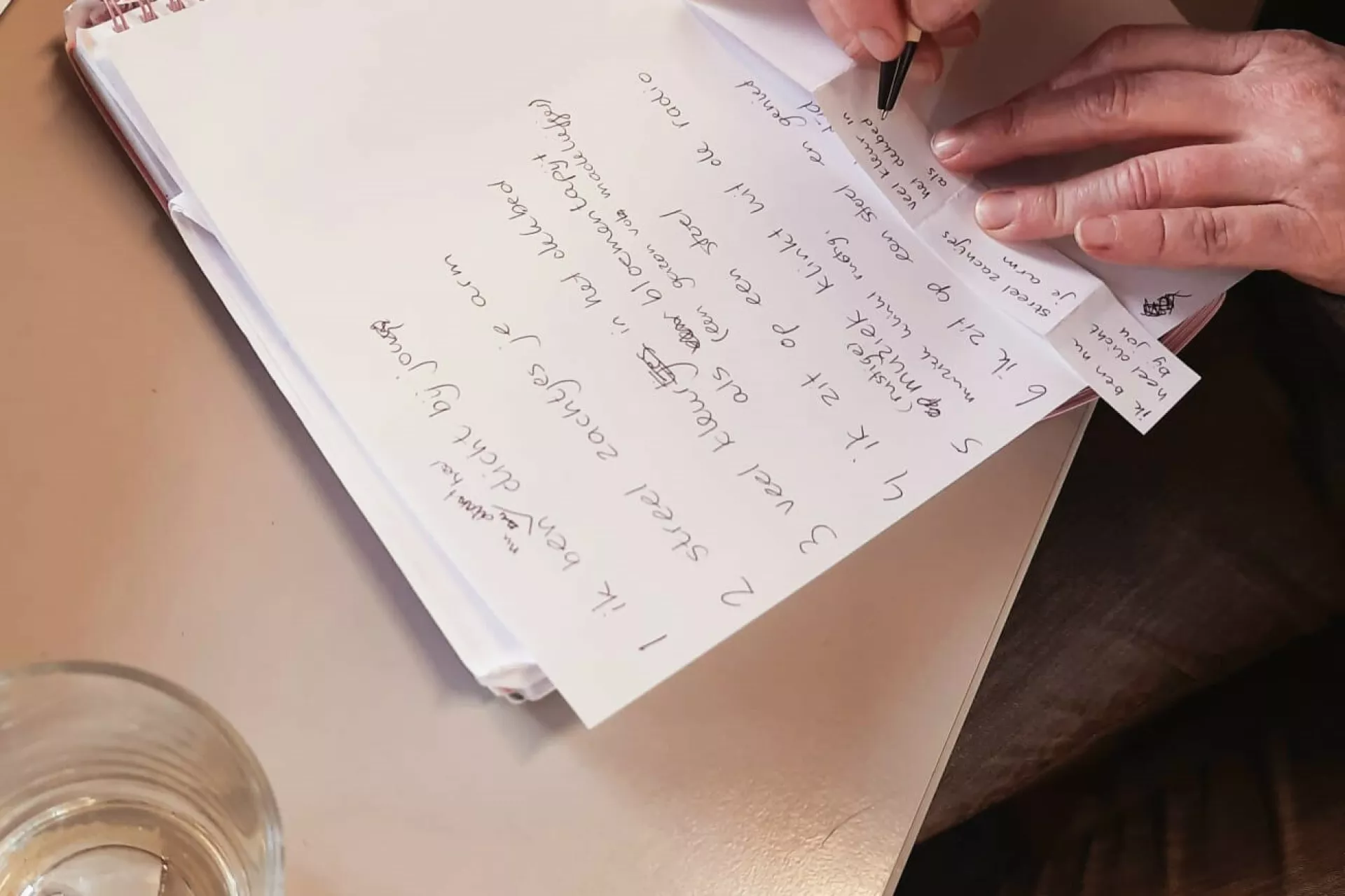 Samenleving - hand die op vel papier schrijft