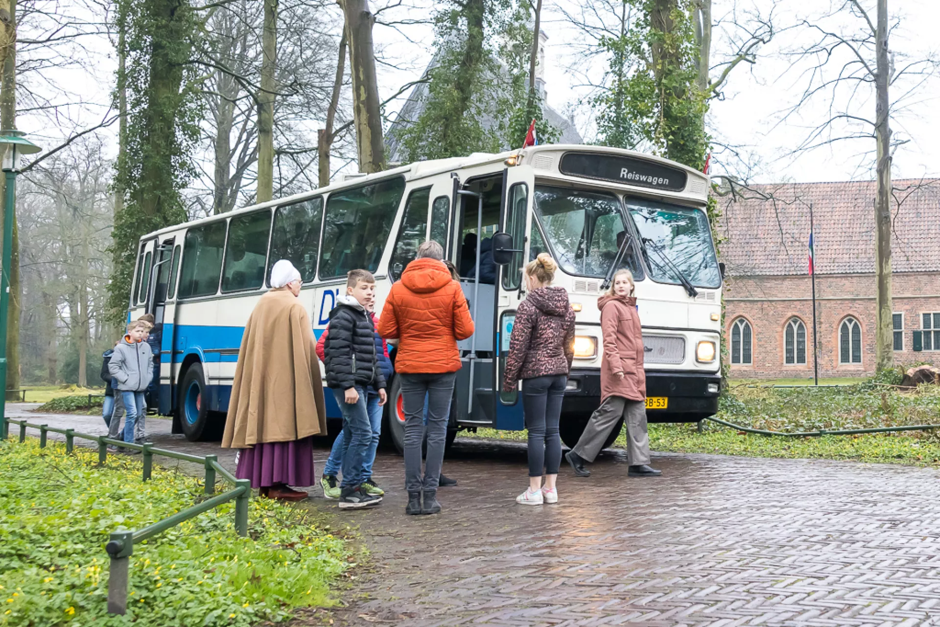 Enkele mensen stappen in een bus op een mistige dag.