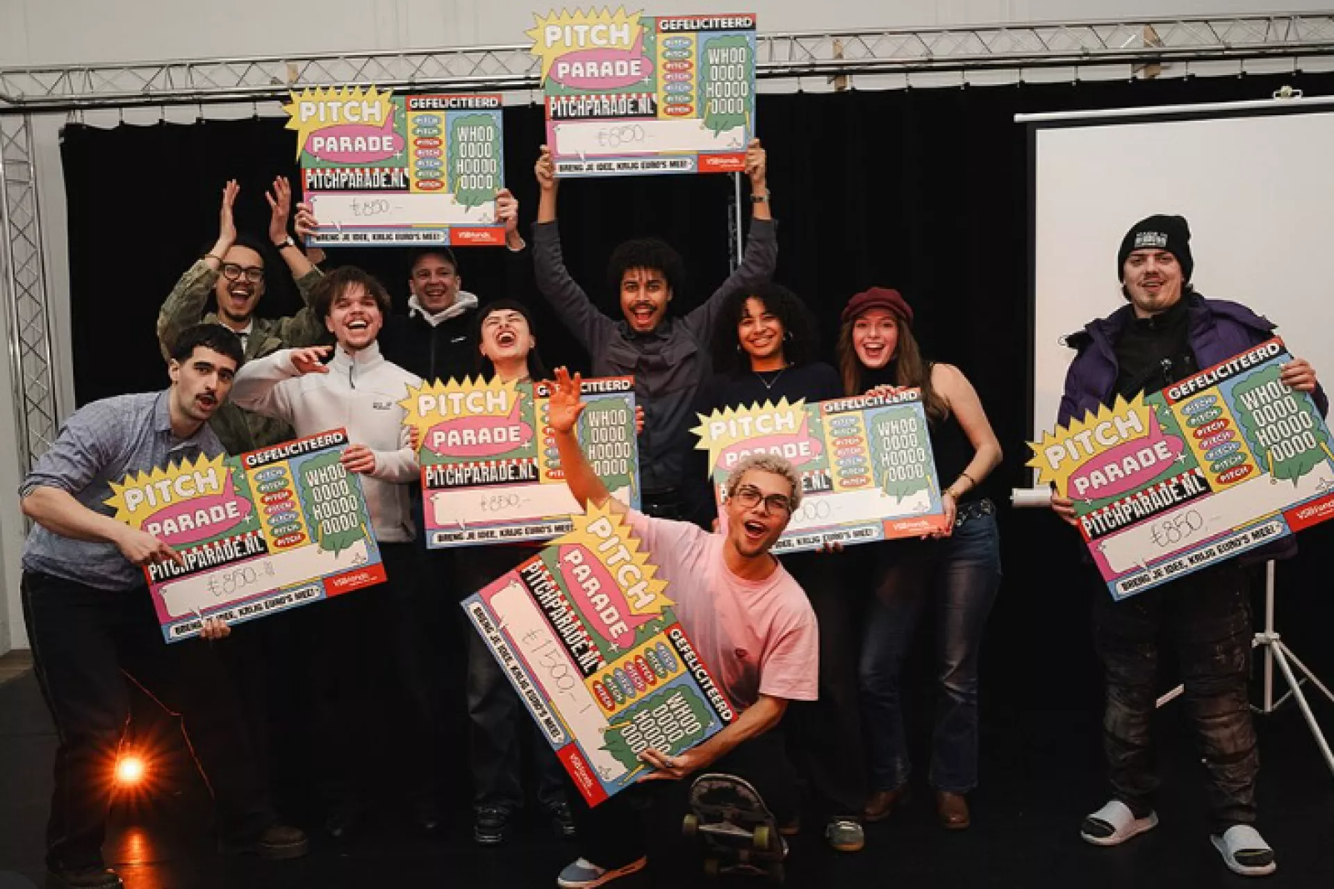 Groep mensen viert een overwinning met kleurrijke posters.
