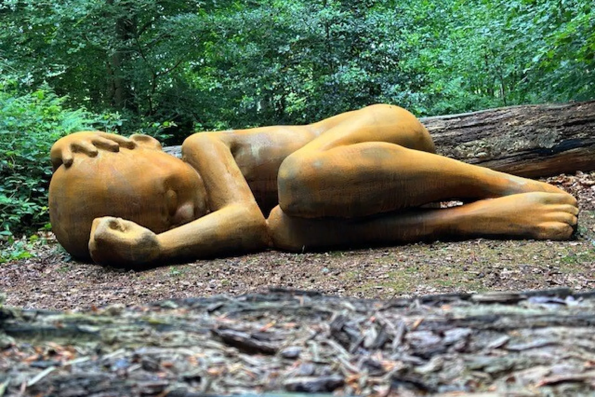 Sculptuur van een liggend kind. Eén van de kunstwerken in het Spaarbankbos.
