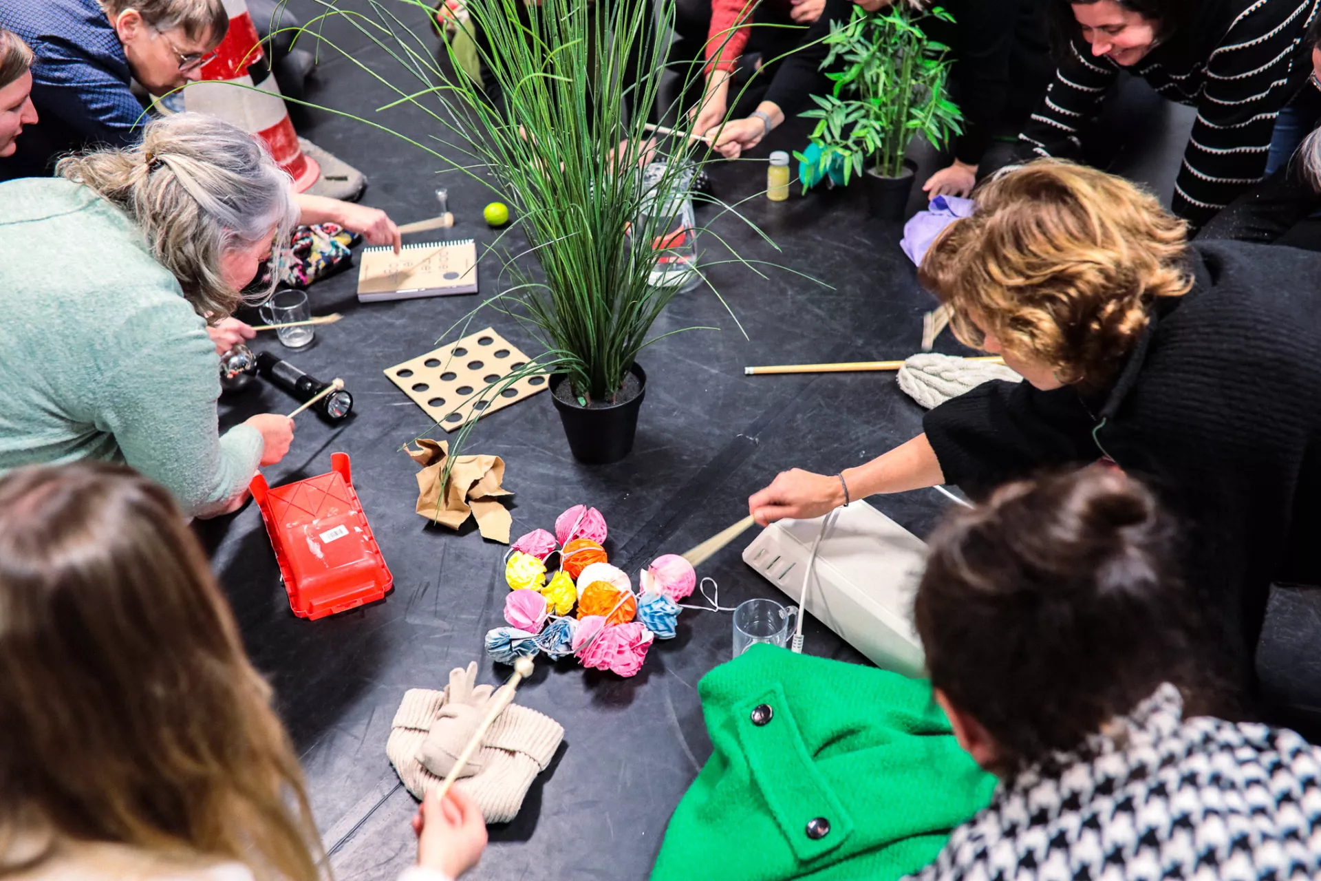 Mensen creëren muziek met alledaagse voorwerpen in een creatieve workshop.