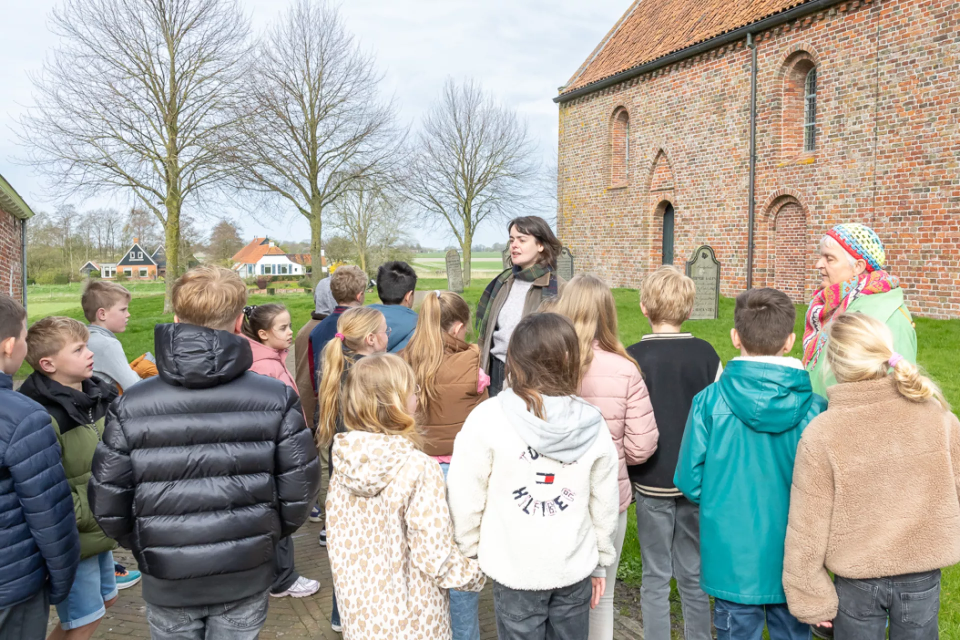 Groep kinderen tijdens een rondleiding bij een kerk museum Wierdenland.