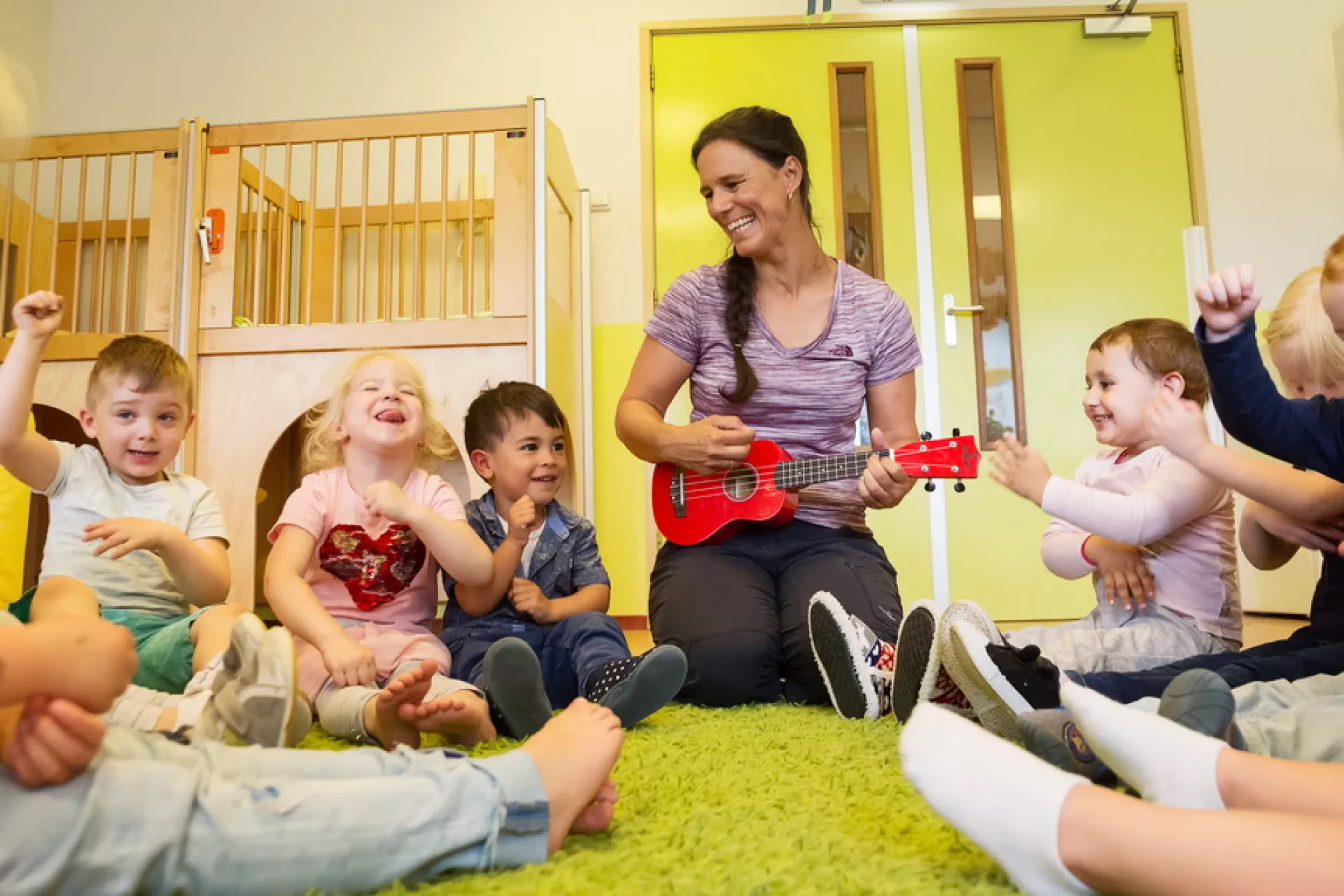 Felice op ukelele tussen kleine kinderen
