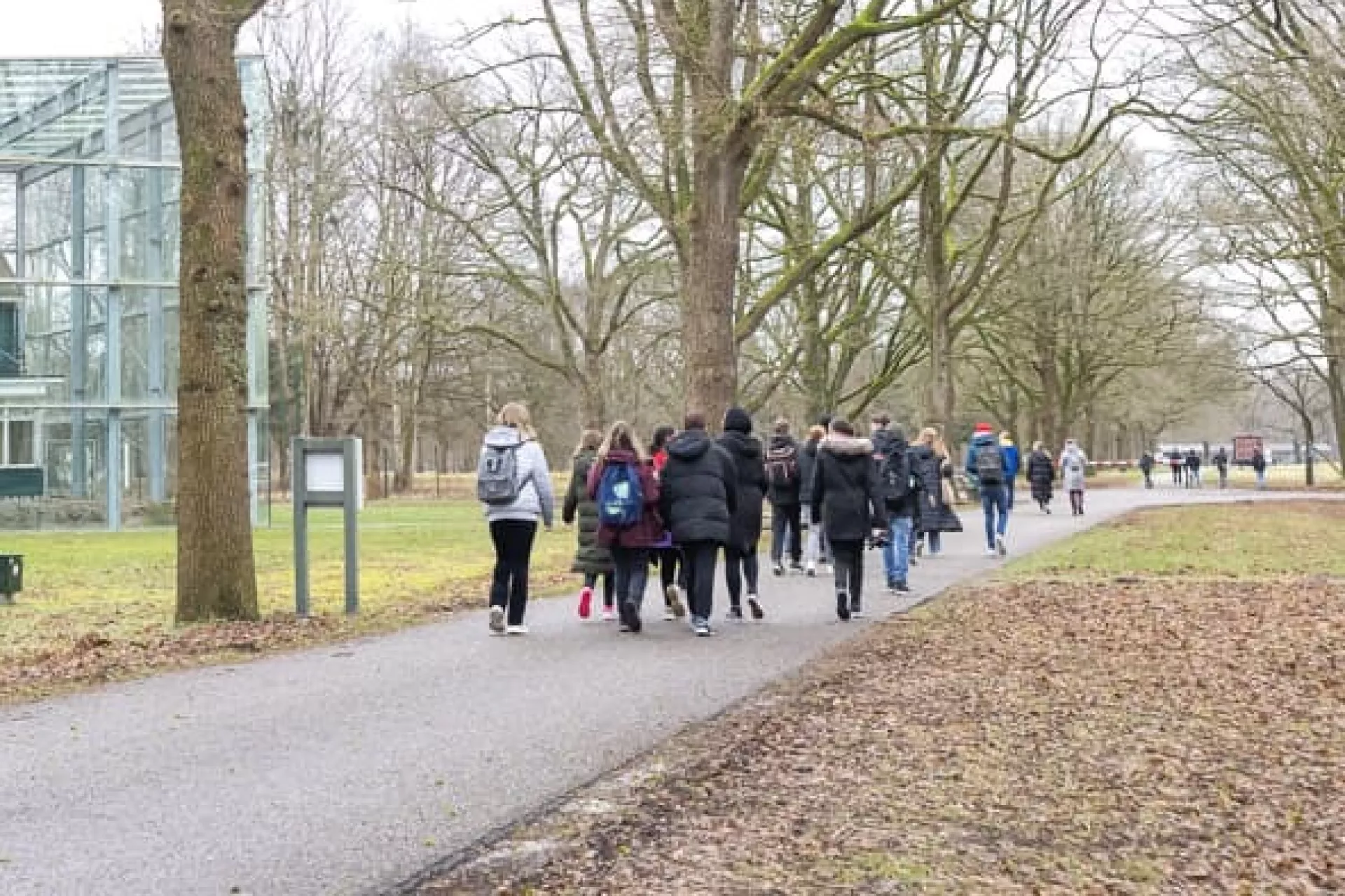 Jongeren lopen langs de kampwoning op het terrein van Herinneringscentrum Kamp Westerbork