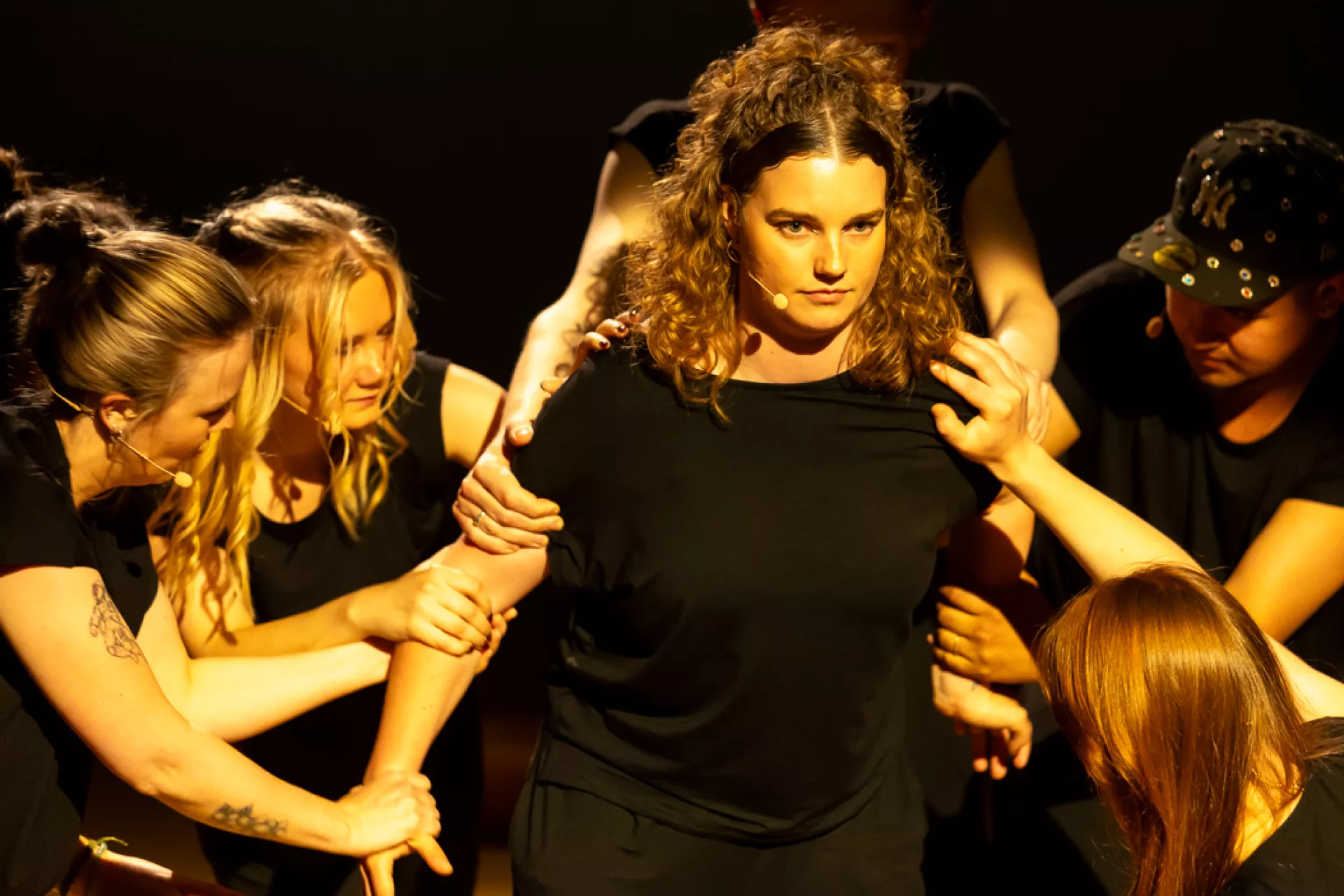 Een groep mensen voert een dramatische scène op in het theater.