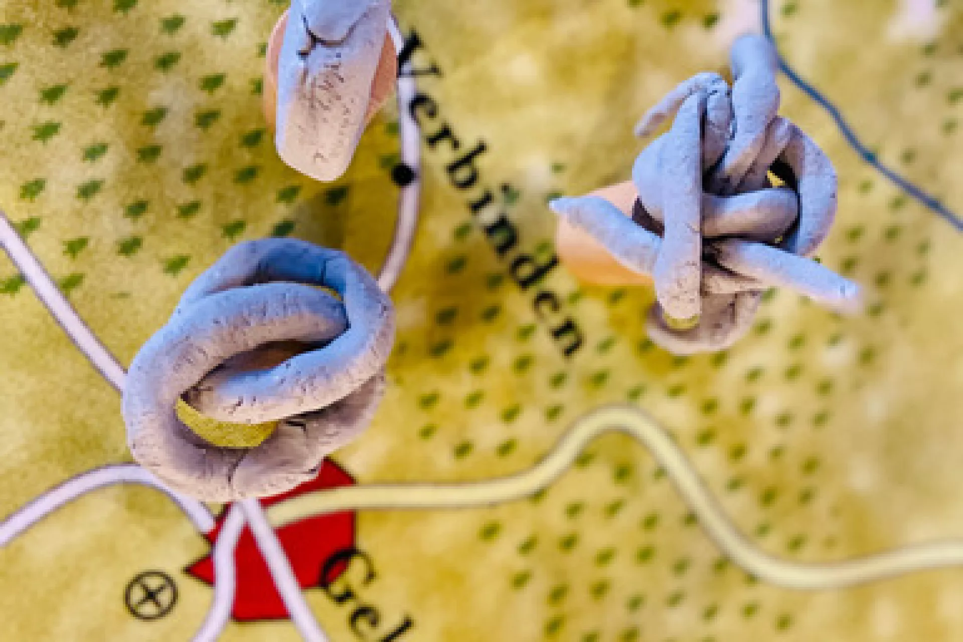 Kaart met draden en knopen geplaatst nabij een rode markering.